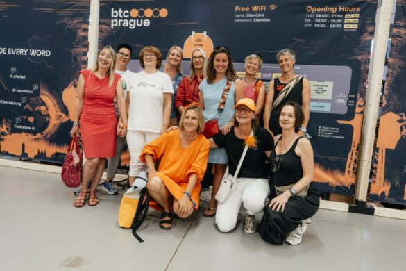 Women Bitcoiners posing at the BTC Prague conference banner
